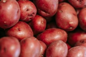 From above of fresh raw red potatoes in straw basket in local grocery market