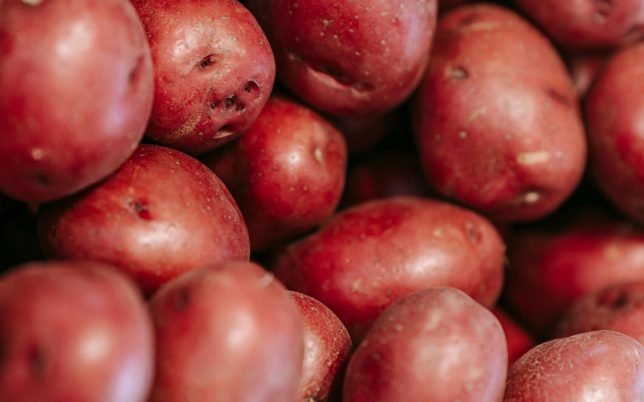 pexels-photo-7129156-7129156 From above of fresh raw red potatoes in straw basket in local grocery market